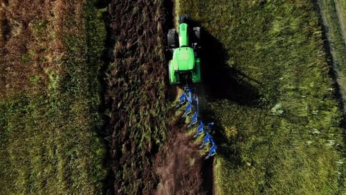 Aerial View of Tractor That Plows Land Preparing Soil for Planting and Cultivating Vegetables or Rye