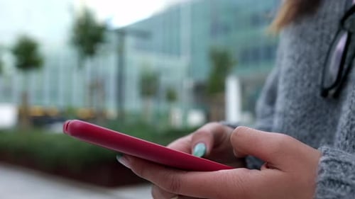 Woman Using Phone Outside Modern Building
