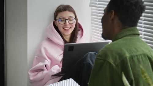 Caucasian Female Programmer Chatting to Black Male Colleague by Window