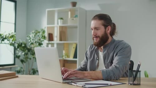 A Man Works at a Computer at Home Feels Joy From His Work Distant Work Home Office