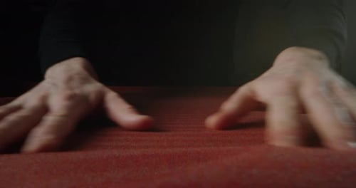 Filmmusik Makroaufnahme eines erfahrenen Schneiders, der mit den Händen den hochwertigen Stoff für die Kreation steuert