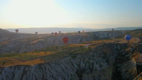 Hot Air Balloons Floating Over Desert Landscape