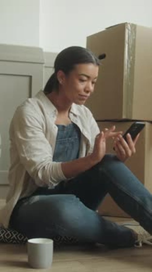 Young Woman Relaxing with Phone in New Home