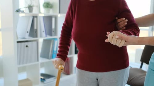 Caregiver Helping Elderly Woman to Walk