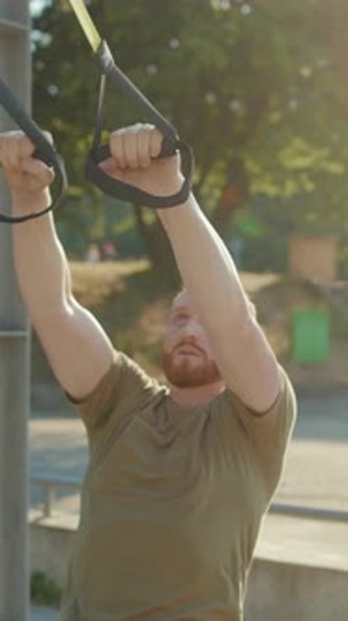 Young Adult Exercising with Straps Outside