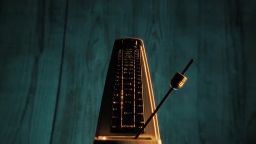 Vintage Metronome Swinging Rhythmically in Close Up