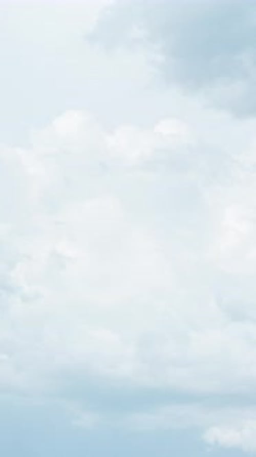 Timelapse of white fluffy clouds. Aerial view of light blue sky Vertical video