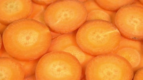 Frisch geschnittene Karotten rotieren als Hintergrund. Karottensaft oder Limonade für Bars, Restaurants,
Cafés