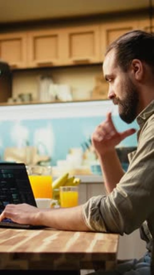 Vídeo vertical de un hombre adulto que usa una computadora portátil para escribir código de programación y desarrollar software