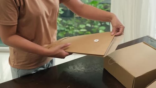 Person Opens Envelope, Reviews Documents Indoors