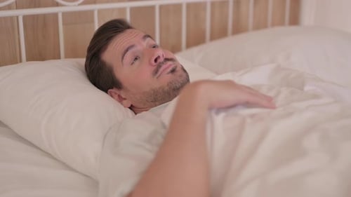 Young Man Waking Up and Leaving Bed