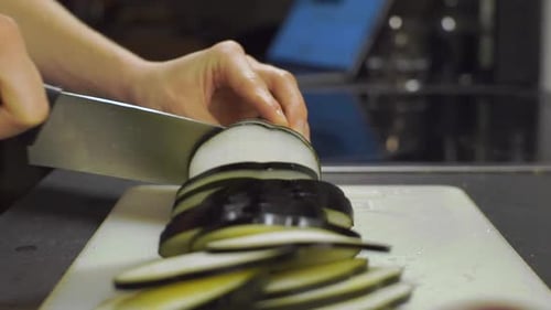 Eggplant being cut by a person