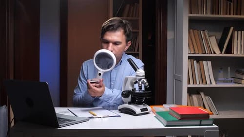Man Examining Sample With Microscope and Magnifying Glass