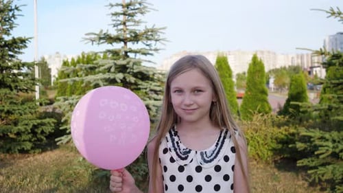 Girl Holding Pink Balloon in the Park