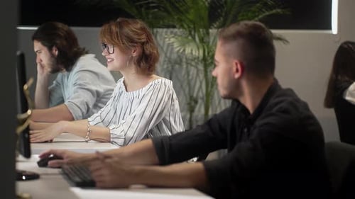 Jeune homme d'affaires discutant avec un collègue sur un ordinateur de bureau