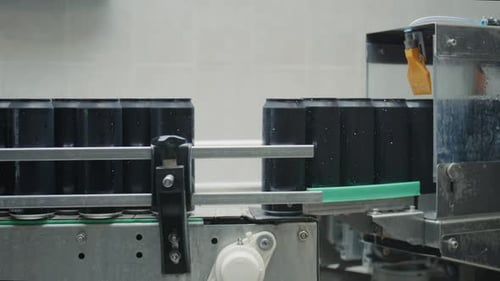 Automated Black Cans Moving on Conveyor Belt