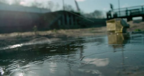 Close up view of a hand smashing the layer of ice on a frozen lake.