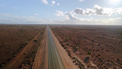 Aerial view above 90mile straight road, australia on partly, sunny day, desert outback - orbit, dron