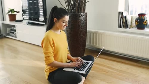 Woman Working on Laptop Sitting Cross-legged on Floor
