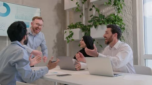 Enthusiastic Team Celebrating Success in Modern Office