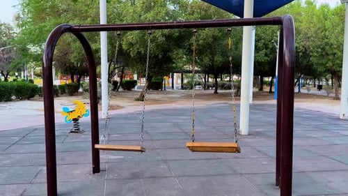 Empty Wooden Swings in Quiet Playground at Dusk