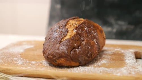 Flour Sprinkled on Bread on Wooden Cutting Board