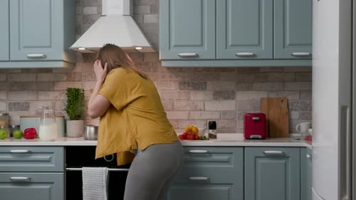 Happy pregnant woman dancing in the kitchen