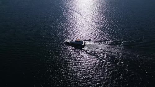 Aerial View of a Small Pilot Boat Cruising on Calm Waters Sunlight Reflecting Off the Ocean Surface