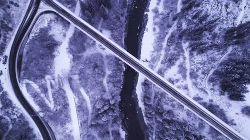 Vista aérea de uma estrada e ponte sinuosa ao longo de um rio sereno e paisagem exuberante