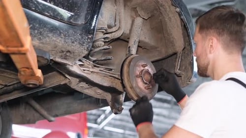 Replacement of Car Brake Pads Manually By a Mechanic in a Garage