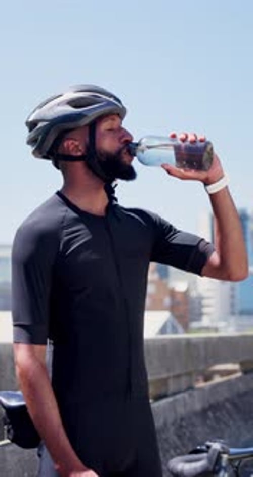 Drinking water, helmet and cyclist outdoor for fitness, hydration and training or practice