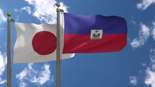 Japan and Haiti National Flags Waving against Blue Sky