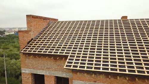 Aerial View of Unfinished Brick Apartment Building with Wooden Roof Structure Under Construction