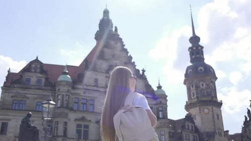 A Young Woman Explores the City Admiring a Large Buildings Beauty