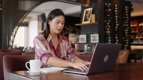 Female Entrepreneur Making Notes when Working in Cafe
