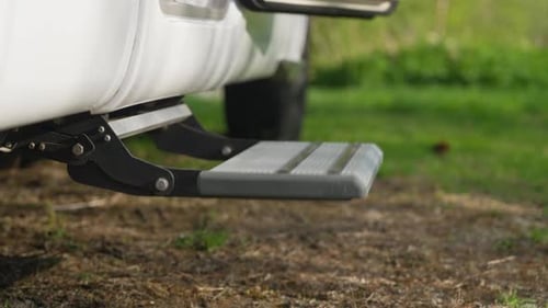 Female stepping out on slippers via electric RV Step, close up