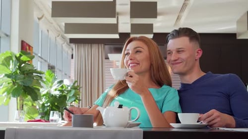 Charming Couple Savoring Morning Tea at a Cozy Cafe Lost in Dreamy Conversation