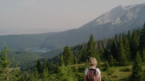 Hiker travel dreadlocks woman with backpack enjoying her adventure - tourism in Montenegro