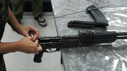 Soldado ajustando los componentes del rifle durante el montaje