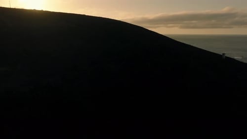 Silhouetted Mountain During Sunset In Malpica, Spain. - aerial reveal