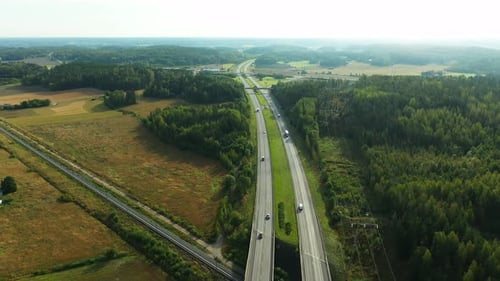 4K Forward moving aerial view of 4-lane highway with cars and trucks passing both directions during