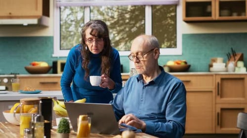 Senior Couple Using Laptop in Bright Kitchen