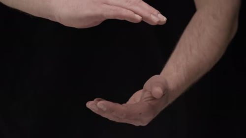 Man's Hands Presenting Invisible Object on Black Background