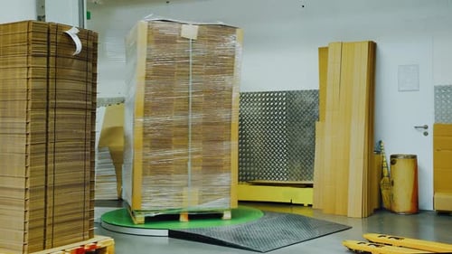 Las cajas de cartón dobladas se empaquetan para su envío en una película de plástico con una máquina especial: cartón moderno.