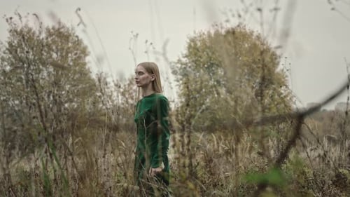 Model posing wearing green dress in field