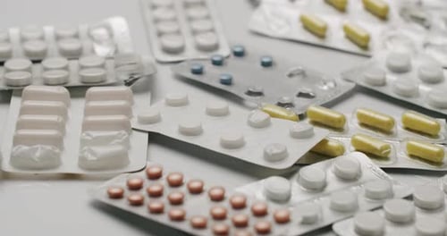 Verschiedene Medikamentenpillen und Kapseln in Blisterpackungen auf weißem Hintergrund