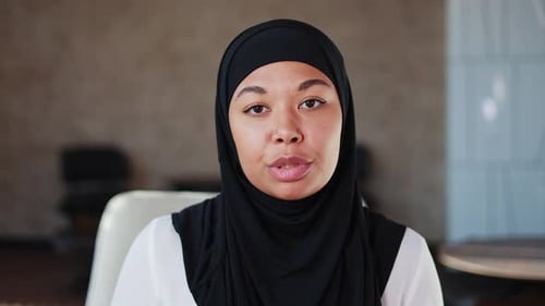 Young Woman Wearing Black Headscarf Speaking to Camera