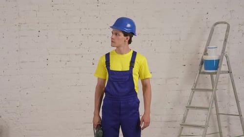 Young Adult with Drill Standing Indoors