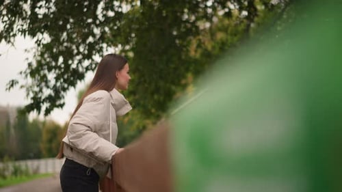 Young Woman Pauses By Park Pathway Contemplative Female in Cozy Jacket Amidst Fall Scenery Serene