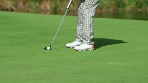 While Playing Golf a Girl Hits the Ball with a Club and It Hits the Hole